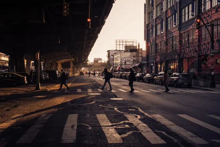 people walk under 3rd Avenue in Brooklyn near Industry City